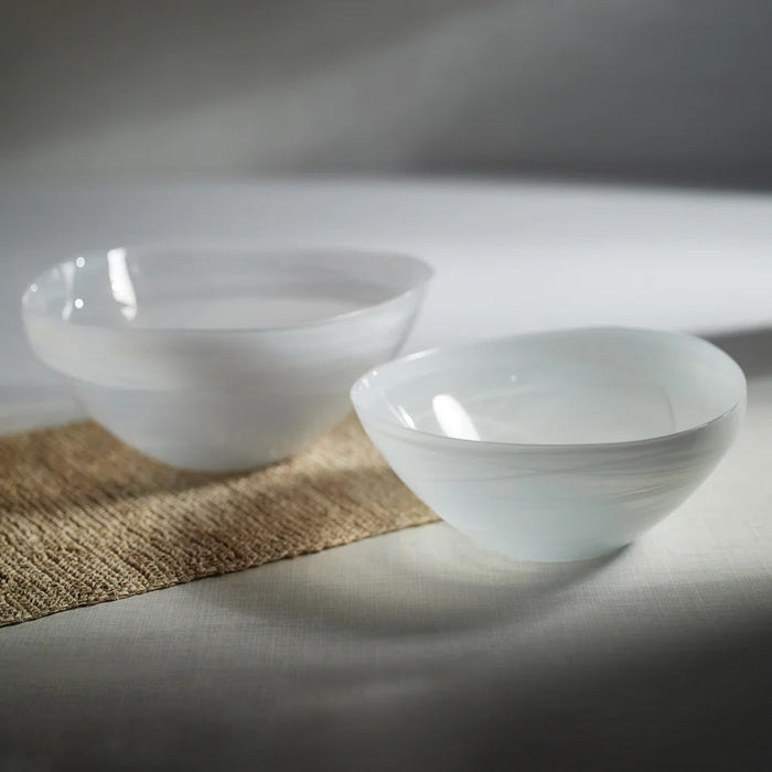 The ZODAX MONTE CARLO ALABASTER GLASS BOWL is a glossy, white, asymmetrical glass bowl measuring 9.75 in x 4.25 in, shown on a white background.