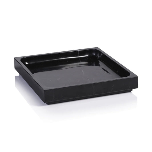 A black bottle of tequila sits on a ZODAX NERO MARQUINA NATURAL MARBLE TRAY - LARGE, accompanied by a black goblet and bowl of chocolate treats, all arranged on a light surface with a dark backdrop.
