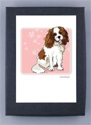 PAPER RUSSELLS - CAVALIER KING CHARLES SPANIEL NOTE CARDS feature a brown and white Cavalier on a pink background with paw prints and flowers, framed in black, printed on FSC certified recycled paper.