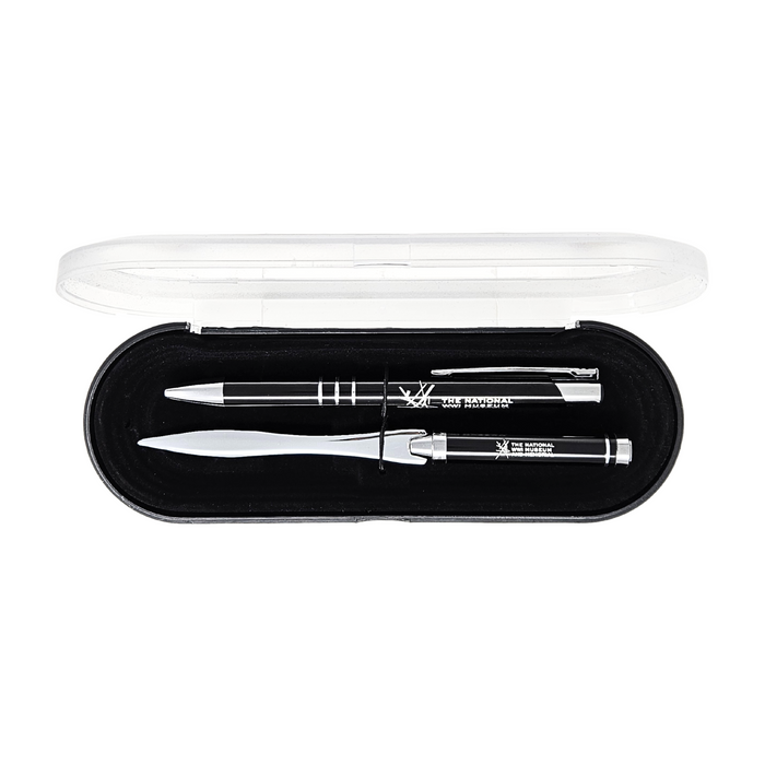 Image that displays a black and silver pen next to a black and silver letter opener. On both item is the logo for the National WWI Museum and Memorial. The set are placed in a plastic box with a black base and a clear plastic cover. Inside the box is a protective velvet fabric that is also black.