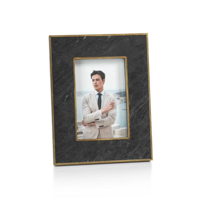 Two ZODAX RENNES GRANITE PHOTO FRAME 4X6 frames sit on a beige surface. The left frame displays a man in a light suit, while the right holds a woman in a black polka dot dress.