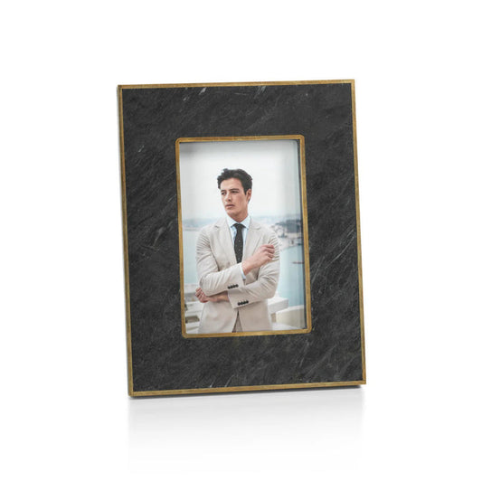 Two ZODAX RENNES GRANITE PHOTO FRAME 4X6 frames sit on a beige surface. The left frame displays a man in a light suit, while the right holds a woman in a black polka dot dress.