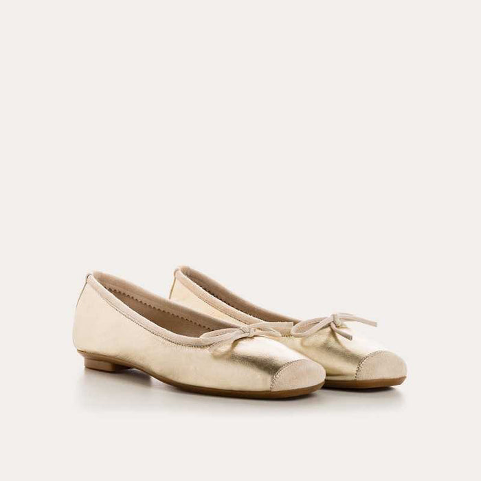 A top view of the REQINS Harmony Bellerina Flat in metallic platinum, featuring a small toe bow and crafted from metallic leather, displayed on a plain light background.
