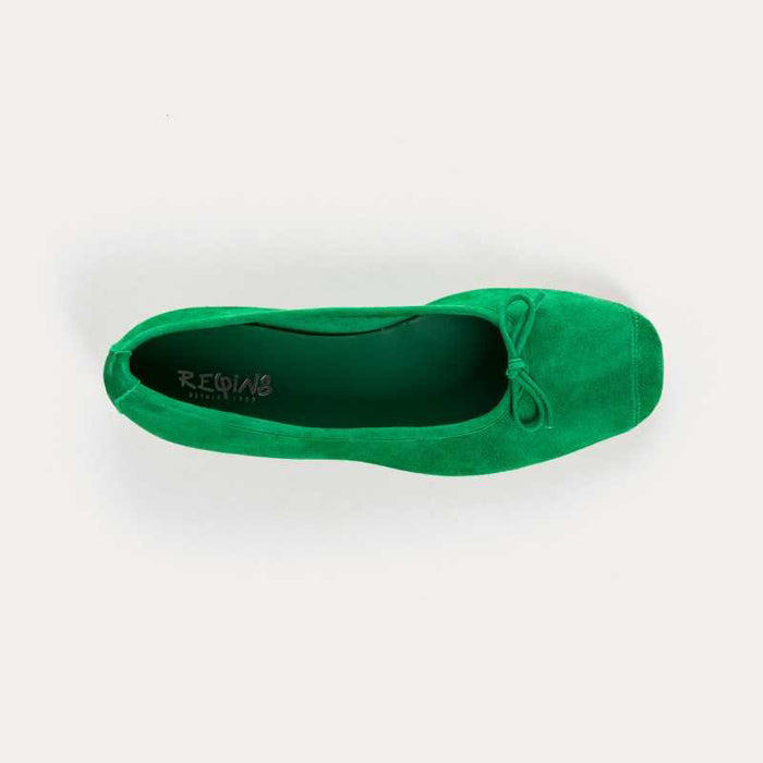 Top view of the REQINS - HARMONY suede ballerina flat in Gazon Green, featuring a small bow on the toe, photographed on a plain light background.