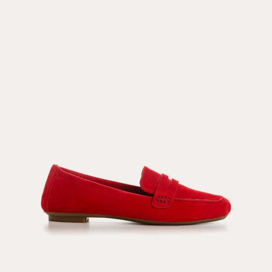 The REQINS HEMA Suede Loafer in Rouge features bright red suede, low heels, a classic penny loafer design, and a supple leather insole—all crafted with artisanal expertise and shown on a plain light background.