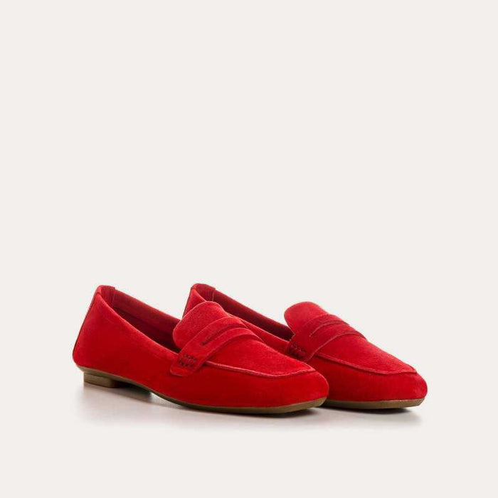 The REQINS HEMA Suede Loafer in Rouge features bright red suede, low heels, a classic penny loafer design, and a supple leather insole—all crafted with artisanal expertise and shown on a plain light background.