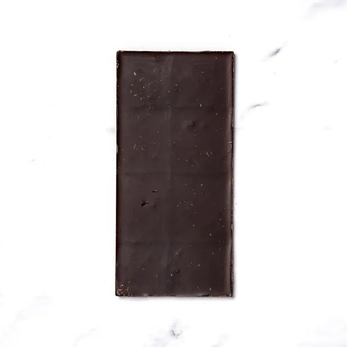 The RITUAL CHOCOLATE - JUNIPER LAVENDER CHOCOLATE bar by RITUAL CHOCOLATE features a purple wrapper with lavender, butterflies, and gold accents. This 70% cacao dark chocolate weighs 2.12 oz (60g) and includes juniper berries and lavender.