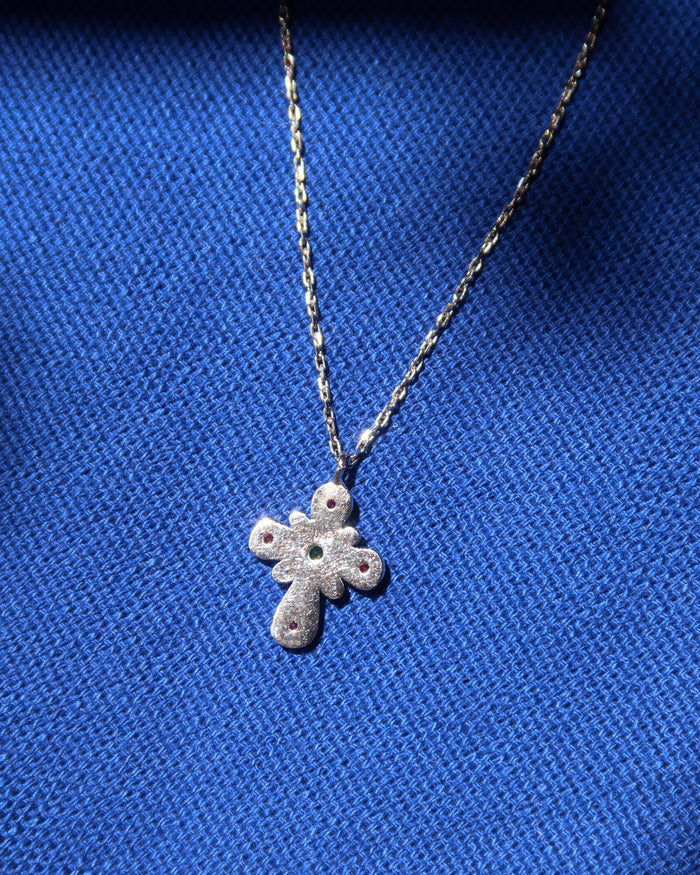 The back of a sterling silver 925 cross pendant necklace on a blue background