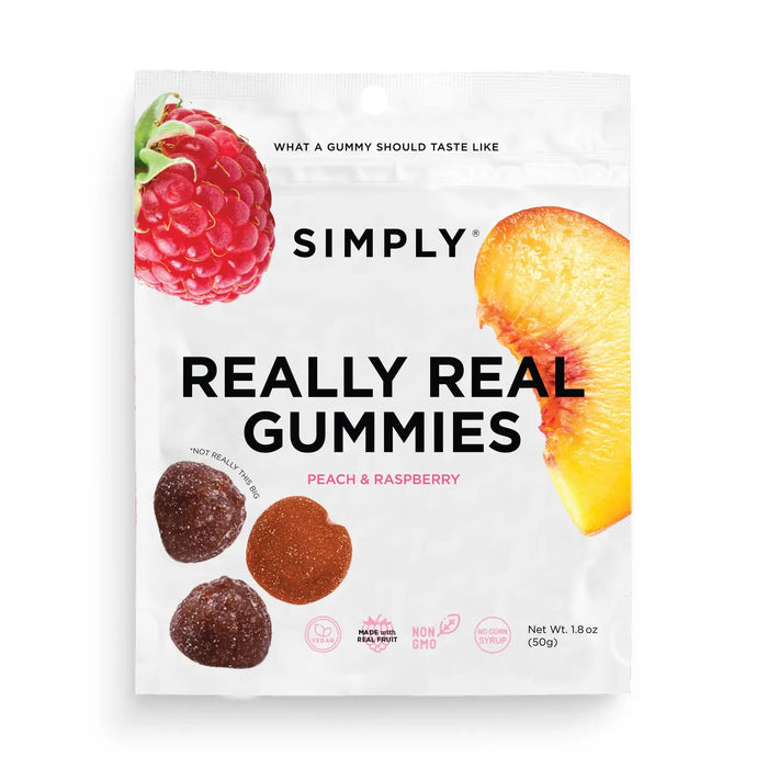 A package of SIMPLY GUM - REALLY REAL PEACH RASPBERRY GUMMIES 1.8OZ made from natural ingredients. The white bag features a raspberry and a peach slice at the top, alongside images of the real fruit gummies at the bottom. Label highlights: "Hot Fruit Trio," "Nutrient Boost," "Non-GMO.