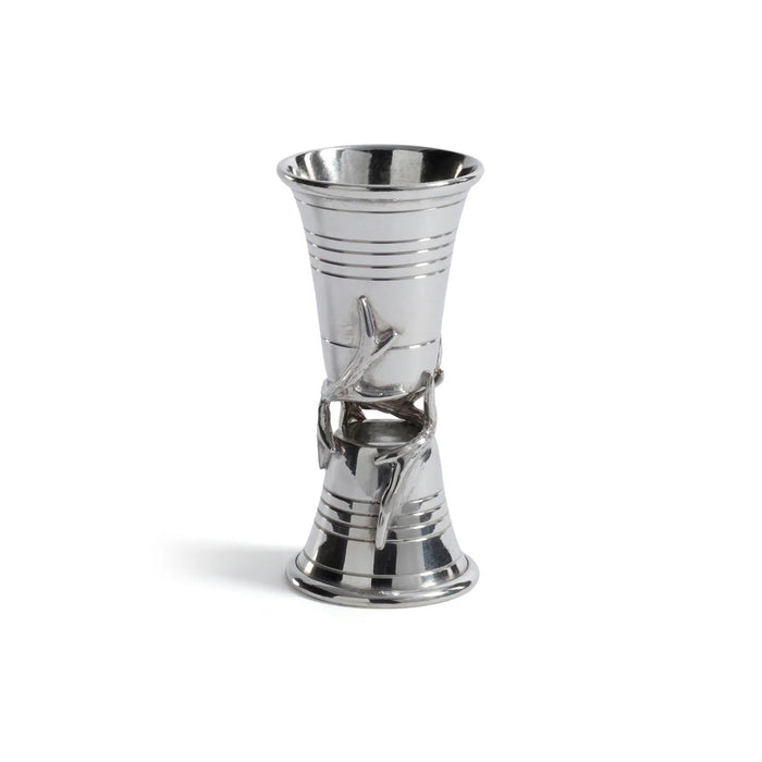 The ZODAX ST. ANTON PEWTER JIGGER is a silver metal jigger with a flared hourglass shape, featuring a sculpted branch and leaf detail around the center. Dimensions: 2 in x 4.25 in.
