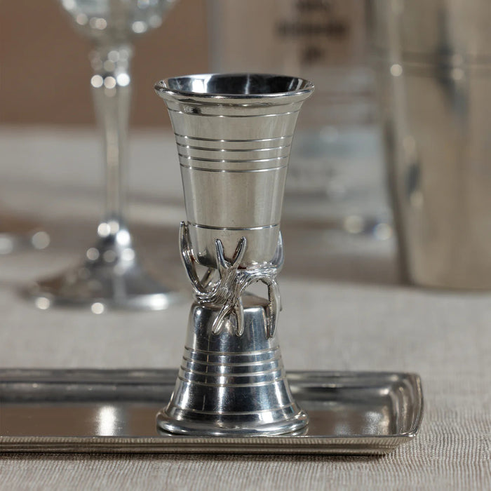 The ZODAX ST. ANTON PEWTER JIGGER is a silver metal jigger with a flared hourglass shape, featuring a sculpted branch and leaf detail around the center. Dimensions: 2 in x 4.25 in.