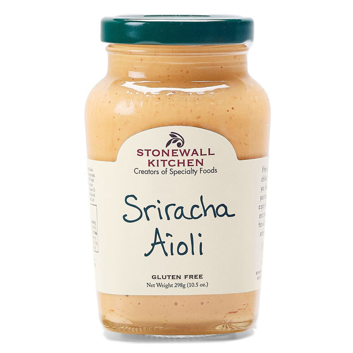 A jar of STONEWALL KITCHEN-SRIRACHA AIOLI features a green lid and beige label with product and brand name, marked "Gluten Free." Inside is creamy, orange, spicy mayo.