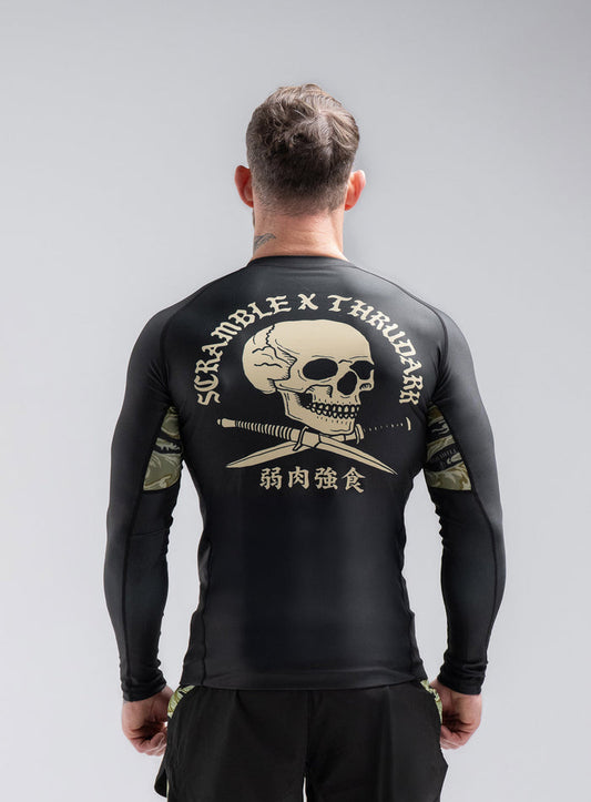 Staz Is 5ft 8" And Wears Size: S | Hem Studio Image Of Model Wearing Thrudark X Scramble Long Sleeve Rash Guard In Obsidian Black (SS Model)