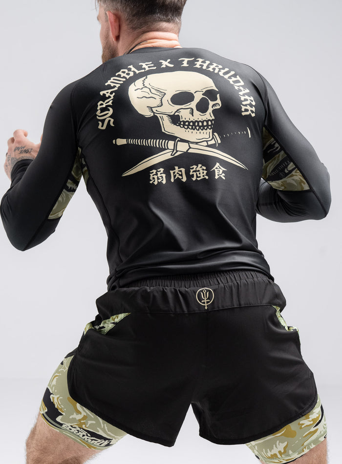 Staz Is 5ft 8" And Wears Size: S | Hem Studio Image Of Model Wearing Thrudark X Scramble Long Sleeve Rash Guard In Obsidian Black (SS Model)
