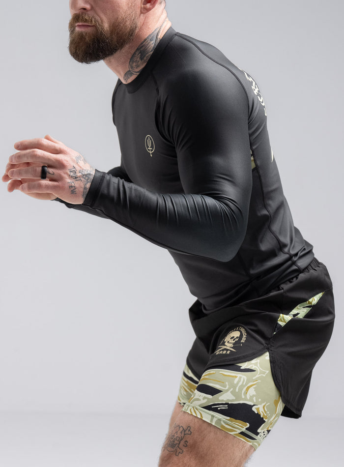 Staz Is 5ft 8" And Wears Size: S | Hem Studio Image Of Model Wearing Thrudark X Scramble Long Sleeve Rash Guard In Obsidian Black (SS Model)