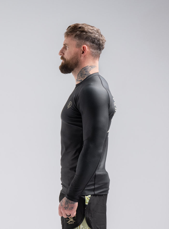 Staz Is 5ft 8" And Wears Size: S | Hem Studio Image Of Model Wearing Thrudark X Scramble Long Sleeve Rash Guard In Obsidian Black (SS Model)