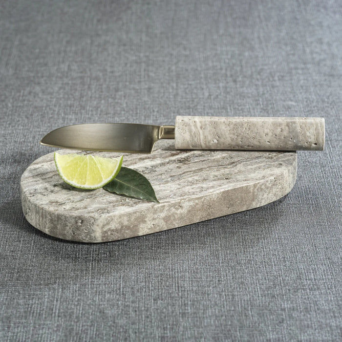 The ZODAX TRAVERTINE MARBLE CUTTING BOARD AND KNIFE set features a metal knife with a stone handle and an oval, marbled gray travertine board, both elegantly displayed against a white background.