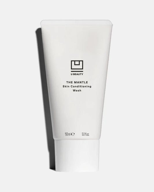 A 150ml tube of U BEAUTY THE MANTLE SKIN CONDITIONING WASH features a minimalist black logo and text on white, displayed against a light background—perfect as the second step in your double cleanse routine.
