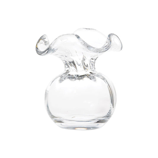 The VIETRI - HIBISCUS BUD VASE CLEAR features a round base and wide, wavy rim, expertly crafted by Tuscan artisans. Displayed against a white background, this clear glass bud vase highlights VIETRI's elegant Italian design.