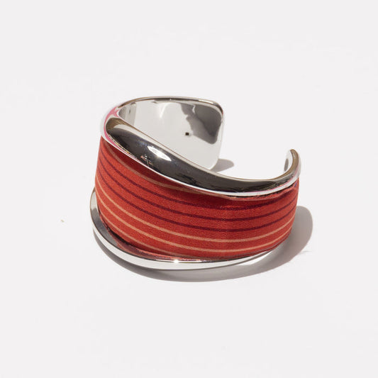 The MILANO MM33 VINTAGE SCARF BANGLE (RED) is a wide silver cuff bracelet with a glossy finish and red-orange stripes, inspired by vintage silk scarves and shown on a white background.